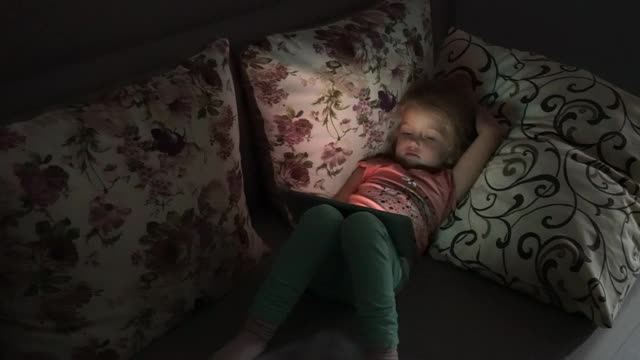 小女孩躺在沙发上看动画片视频下载