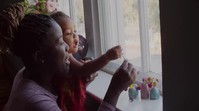 一位年轻的母亲和她的女儿望着窗外视频素材