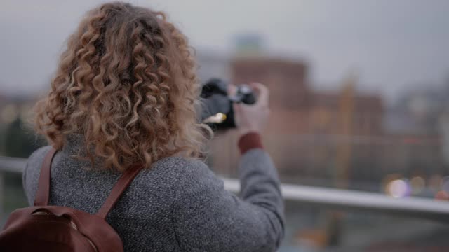 陌生的女摄影师在城市里拍摄照片视频素材