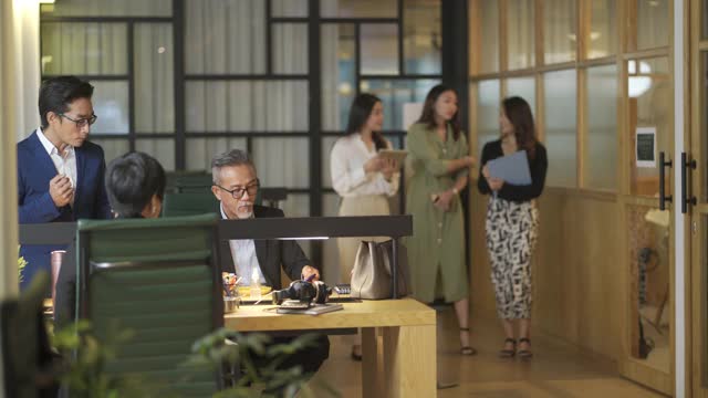 一群亚洲华人白领女商人在办公室里散步讨论视频素材