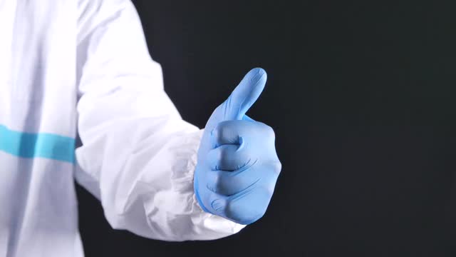 特写一拖人的手在医疗手套显示一个大拇指向上。视频下载