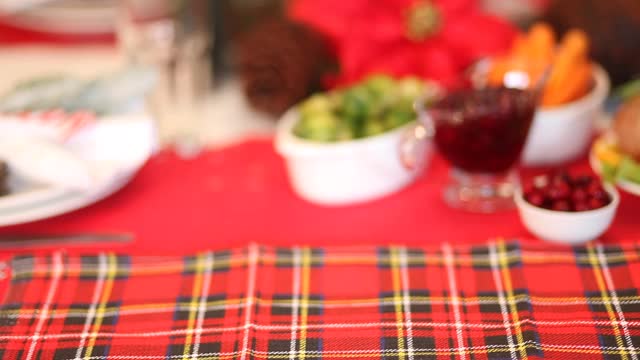 感恩节或圣诞节晚餐的餐桌女人用手把盛满烤火鸡的盘子放在桌子上。庆祝传统节日视频素材