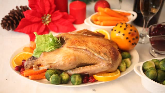 感恩节或圣诞节晚餐的餐桌女人手工装饰填充烤火鸡。庆祝传统节日视频素材