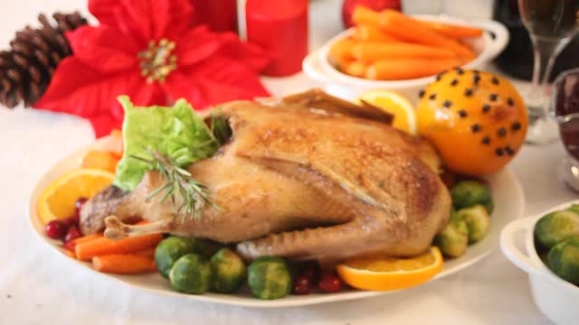 感恩节或圣诞节晚餐的餐桌女人手切塞满馅的烤火鸡。庆祝传统节日视频素材