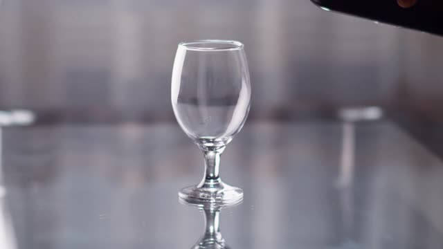 红酒从瓶子里倒进玻璃杯，背景是一扇窗户视频下载