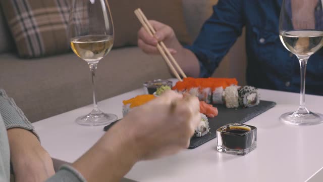 两个女性朋友坐在桌边吃寿司。家庭、友谊和沟通理念。视频素材