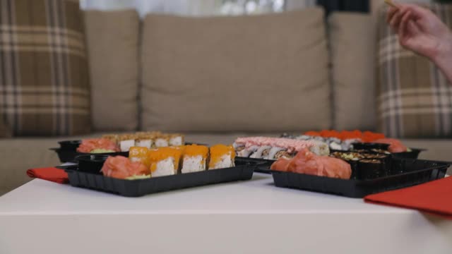 两个女性朋友坐在桌边吃寿司。家庭、友谊和沟通理念。视频下载