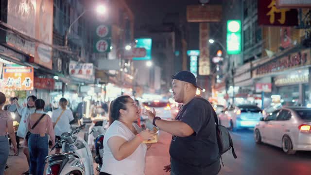 一对甜蜜的情侣在曼谷Yaowarat路享受街边小吃视频素材