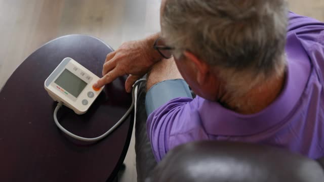 老人在家用自动血压仪检查血压视频下载