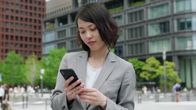 日本女商人在路上使用智能手机视频素材