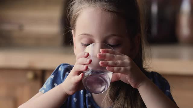 近距离观看小女孩拿着杯子喝天然水视频素材