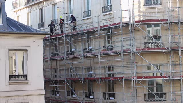 工人们拆除巴黎一座建筑上的脚手架视频素材