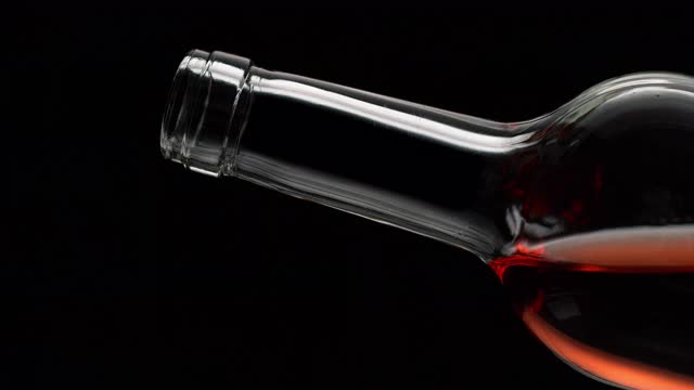 用慢动作从一个透明的瓶子里倒出玫瑰酒视频素材