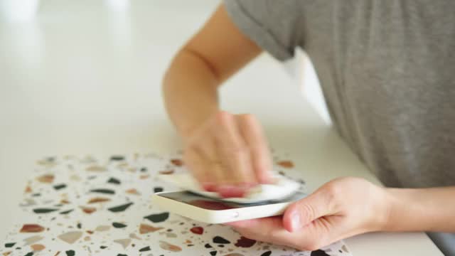 女人用纸巾擦手机屏幕视频素材