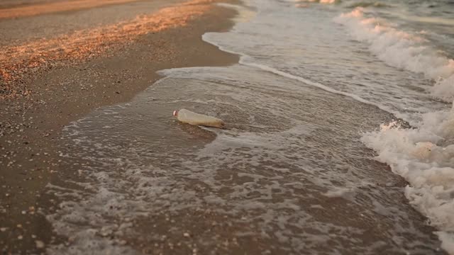 海浪把废弃的塑料垃圾带到沙滩上视频素材
