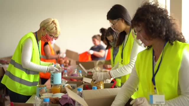 大流行期间，志愿者在仓库收集捐赠的食物视频素材