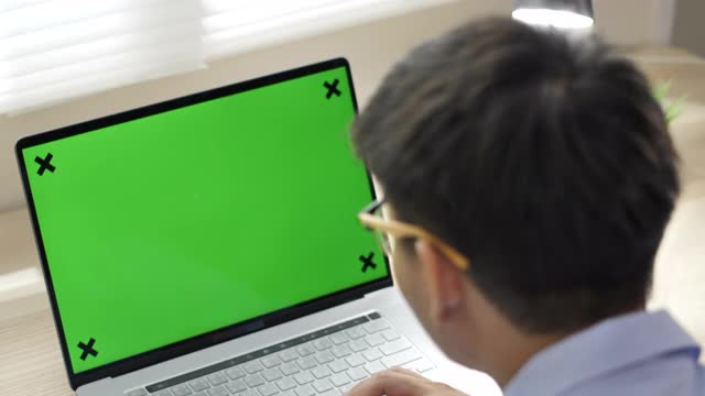 商人看着笔记本电脑的绿屏视频素材