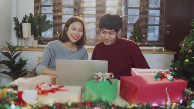 年轻的亚洲夫妇视频电话与家人在家里的礼盒视频素材