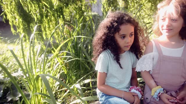 两个可爱的小女孩一起站在花园里视频素材