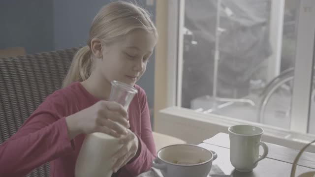 少女们把牛奶倒在装满Cheerios的碗上互相微笑视频下载