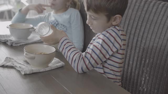 男孩把牛奶倒在满碗的Cheerios上视频下载