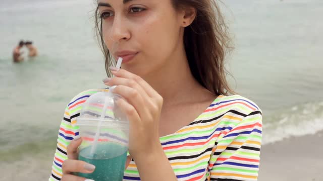 一个女人享受热带鸡尾酒的特写视频素材