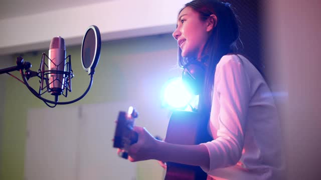 年轻的声学女歌手记录音乐与耀斑光视频素材