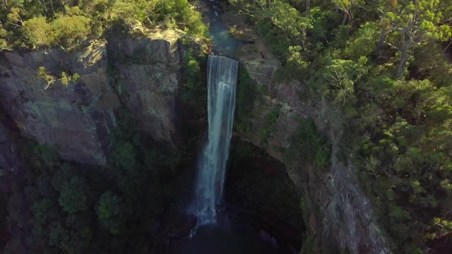 空中摇摄:美丽的瀑布从岩石悬崖在树-贝尔摩瀑布，澳大利亚视频素材