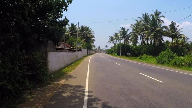 在阳光明媚的日子里，建筑物和树木之间的道路-加勒，斯里兰卡视频素材
