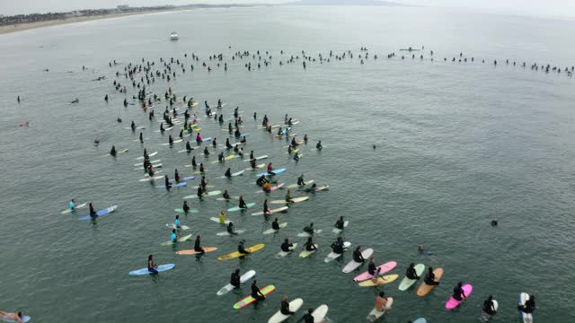 空中向前飞盘:冲浪者在抗议期间在海里溅水-圣塔莫尼卡，加利福尼亚视频下载