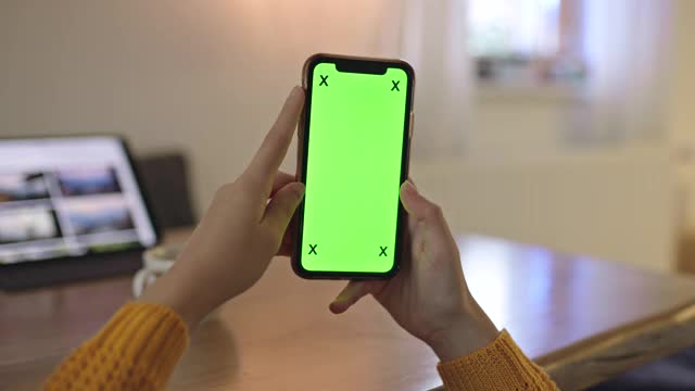 MS Woman的手在家里用彩色键绿色屏幕的智能手机视频素材