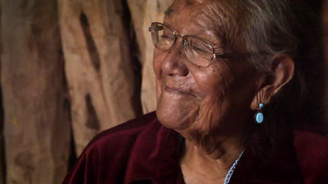 亚利桑那州纪念碑谷，一位微笑的年迈纳瓦霍祖母坐在她的正宗霍根手杖里的视频肖像视频下载