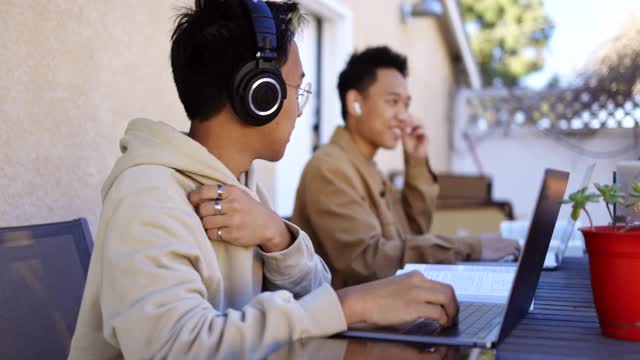 拥有笔记本电脑的菲律宾家庭在后院里围着桌子工作视频下载