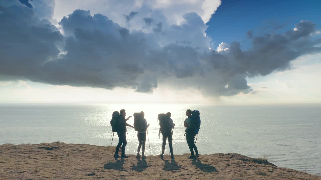 四名游客站在山顶，以海景为背景视频下载