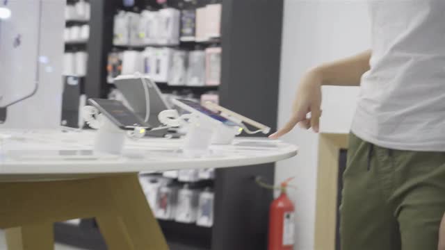 女孩在超市用平板电脑和智能手机选购商品视频素材