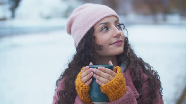 一名年轻女子在雪地里喝热巧克力视频下载