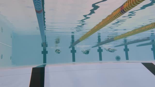 女游泳运动员正在进行蝶泳动作-水下前视射击视频素材