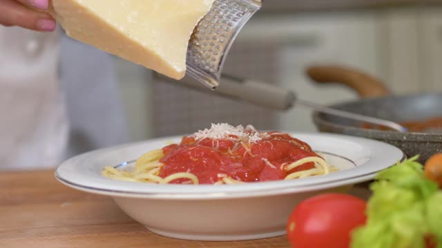 厨师把帕尔玛干酪磨碎在意大利面上视频素材