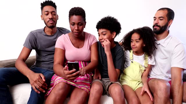 偶然的跨种族幸福家庭坐在家里的沙发上视频下载