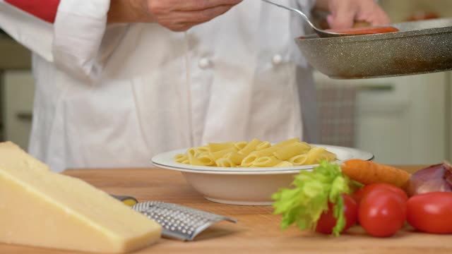 厨师把帕尔玛干酪磨碎在意大利面上视频素材