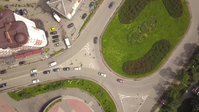上下鸟瞰图的环岛街道交叉口与移动的汽车交通。视频素材