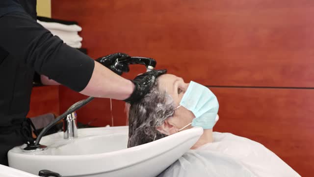染发师在COVID-19发生时调理病人头发视频素材