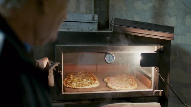 从热烤箱里拿完披萨的人视频素材