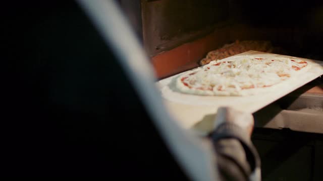 把两个披萨放进热烤箱视频素材