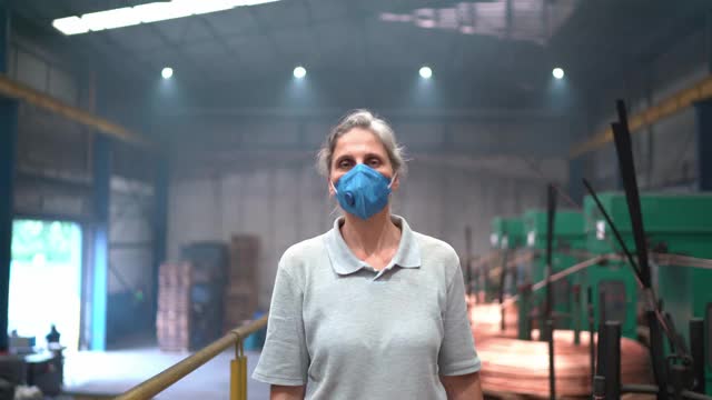 一个成熟女人双臂交叉站在工厂里的肖像视频下载
