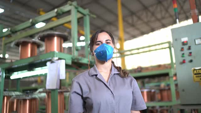一幅年轻女子双臂交叉站在工厂里的肖像视频下载