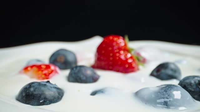 移动近距离拍摄水果碗与草莓蓝莓和酸奶牛奶视频素材