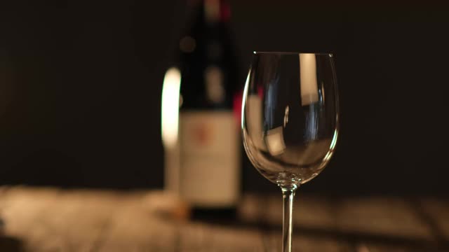 侍者把红酒倒进放在木质餐桌上的玻璃杯里视频下载