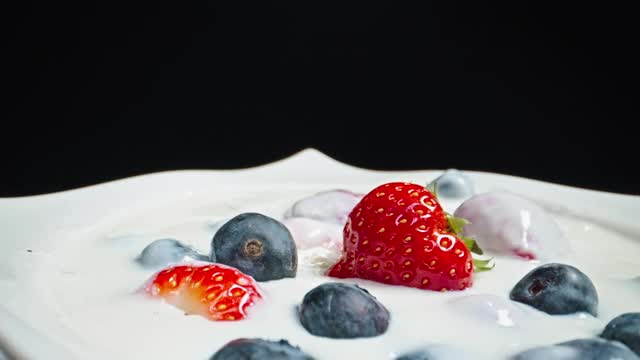 缓慢移动的近距离镜头水果碗与草莓蓝莓和酸奶牛奶视频素材