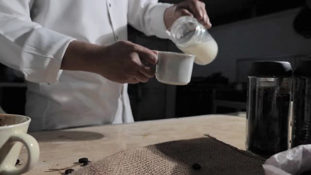 制作热奶油咖啡，咖啡师把鲜奶油倒进咖啡杯视频素材